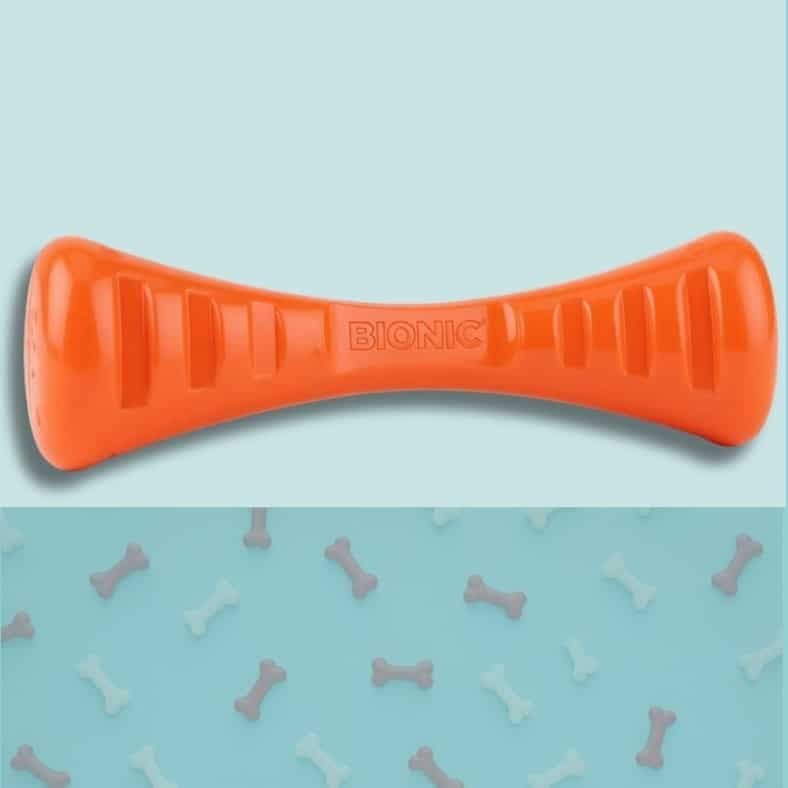 Jouet pour chien orange vif, en forme d'os stylisé, avec le logo BIONIC gravé au centre.