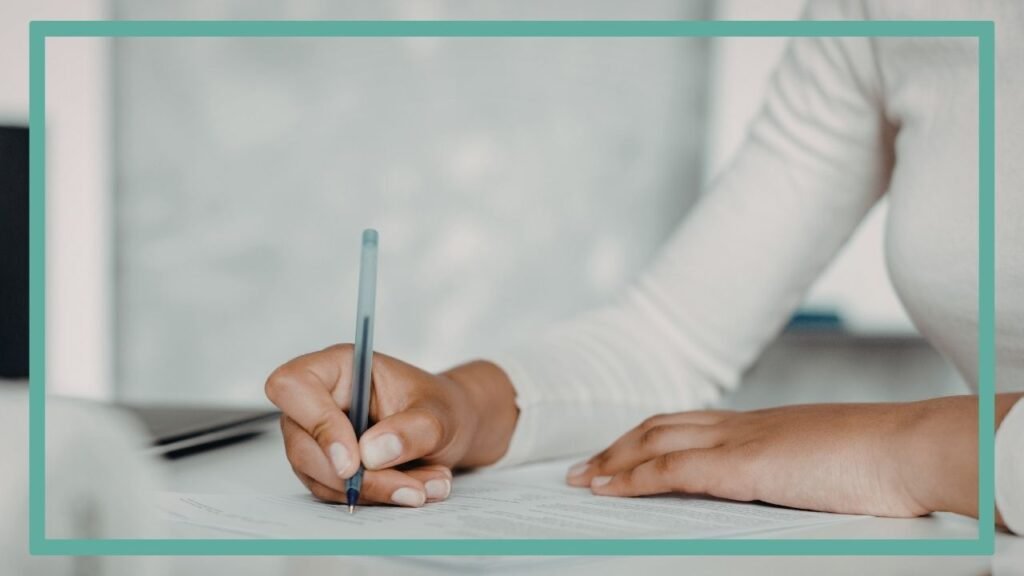 Photographie représentant une main féminine signant des documents. Ils s'agit de tous les documents à signer et à vérifier pour éviter un élevage de chiens frauduleux.